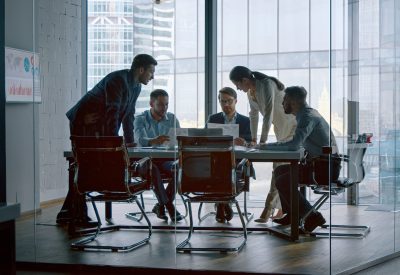 Young businesswoman telling colleagues her development vision at a meeting in office